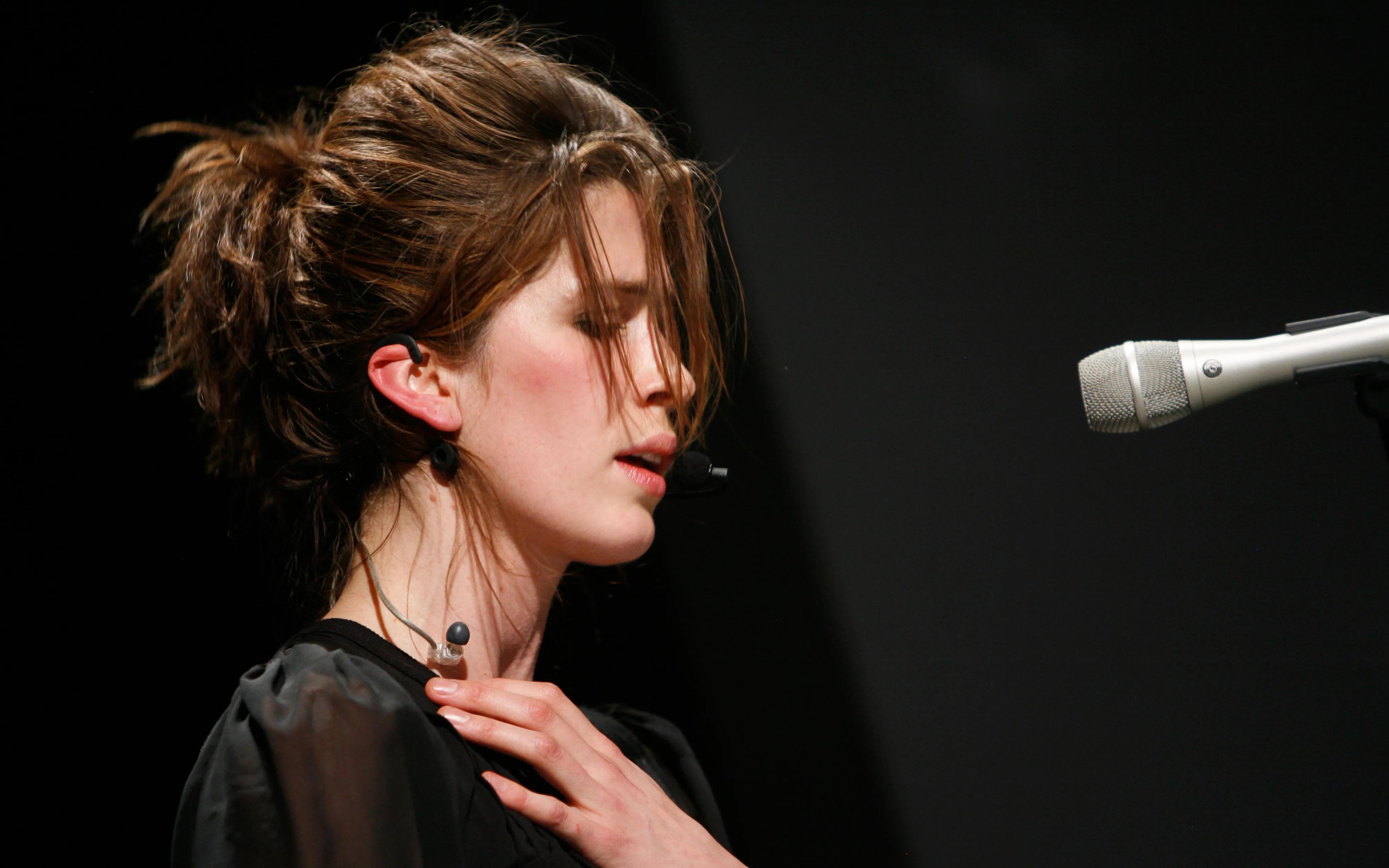Singer Imogen Heap singing into a microphone