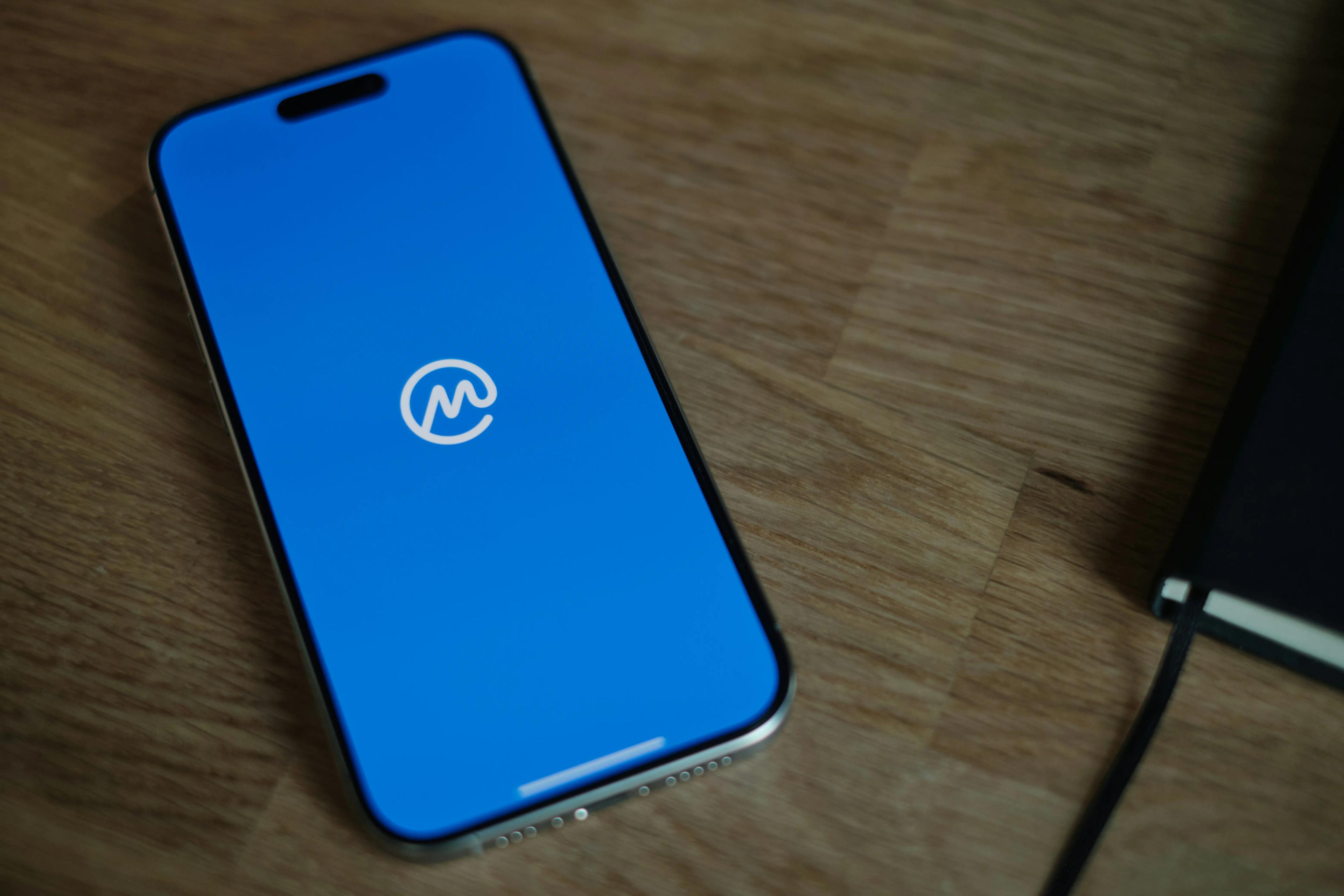 A smartphone displaying the CoinMarketCap logo