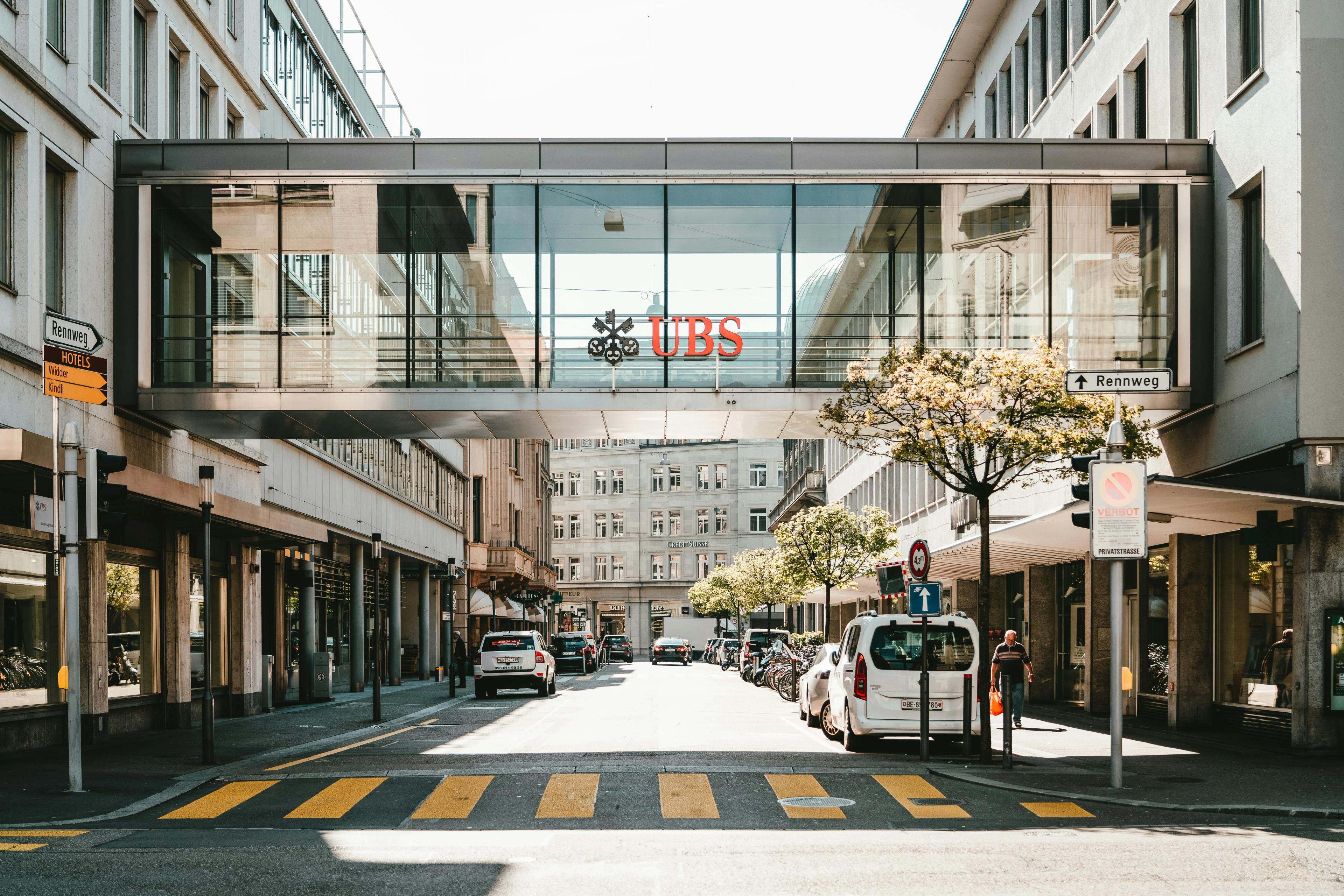 A street with a bridge over the top emblazoned with the UBS logo
