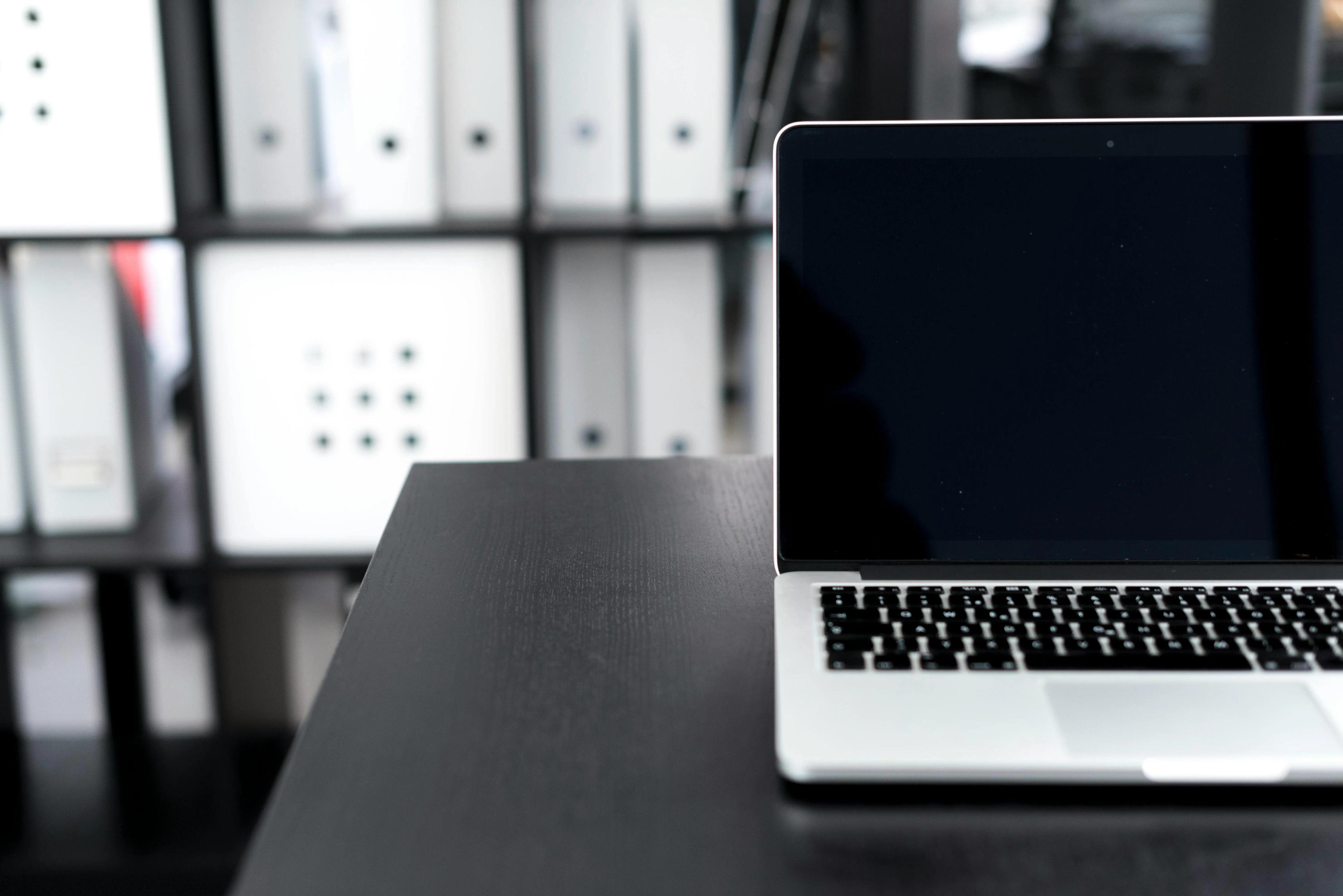Black-and-white photo of an laptop on a table