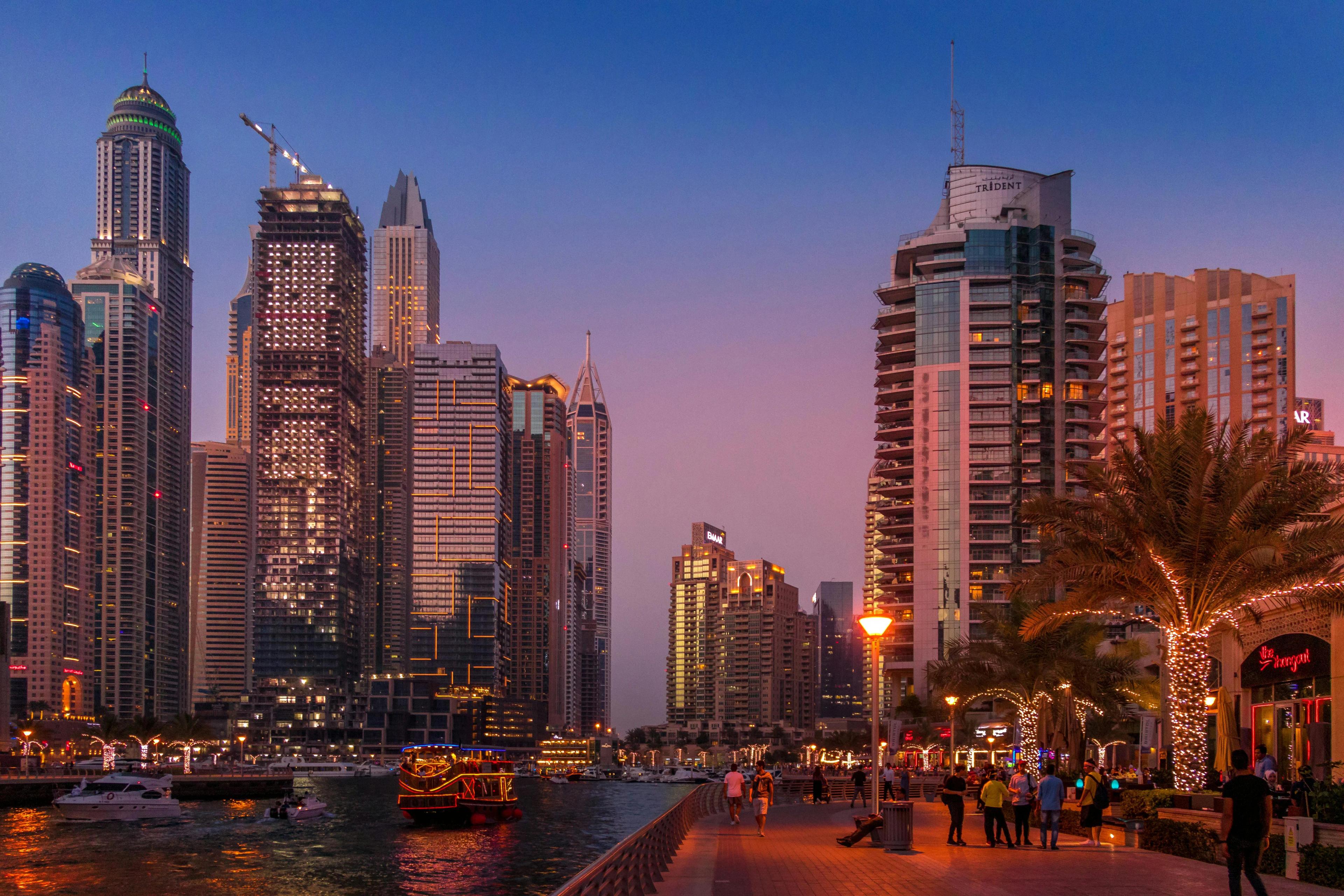 Dubai cityscape with tall buildings and boats on the marina
