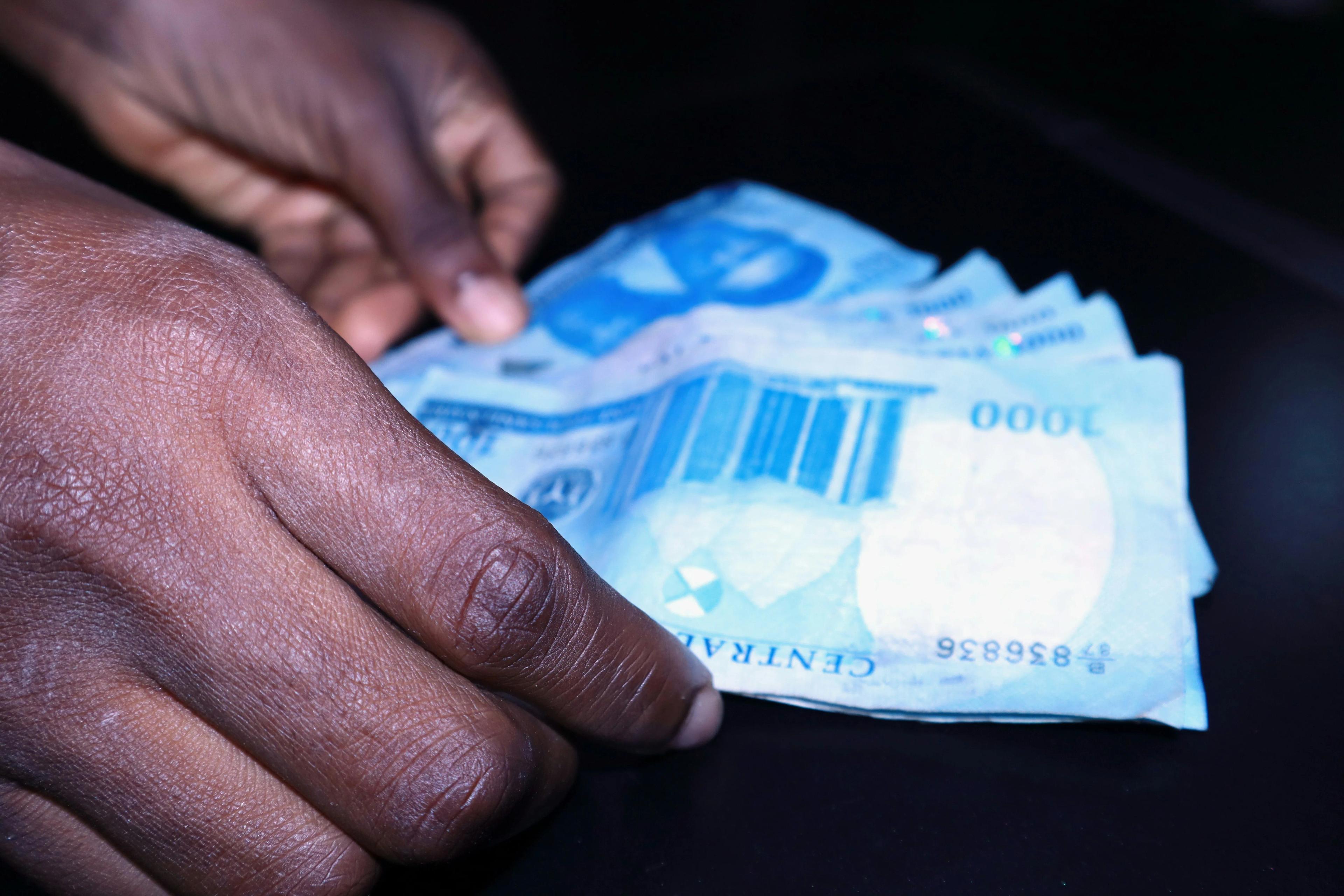 Hand of African man holds blue bank notes